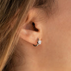 Close-up of a woman’s ear wearing Diamond Heart Huggies—dainty silver hoops with sparkling diamonds, perfect for everyday elegance or as a thoughtful gift.