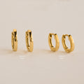 Two pairs of gold hoops, Editor IV 10mm and Editor III Huggies, are displayed on a beige background—ideal for fans of minimalist jewelry.
