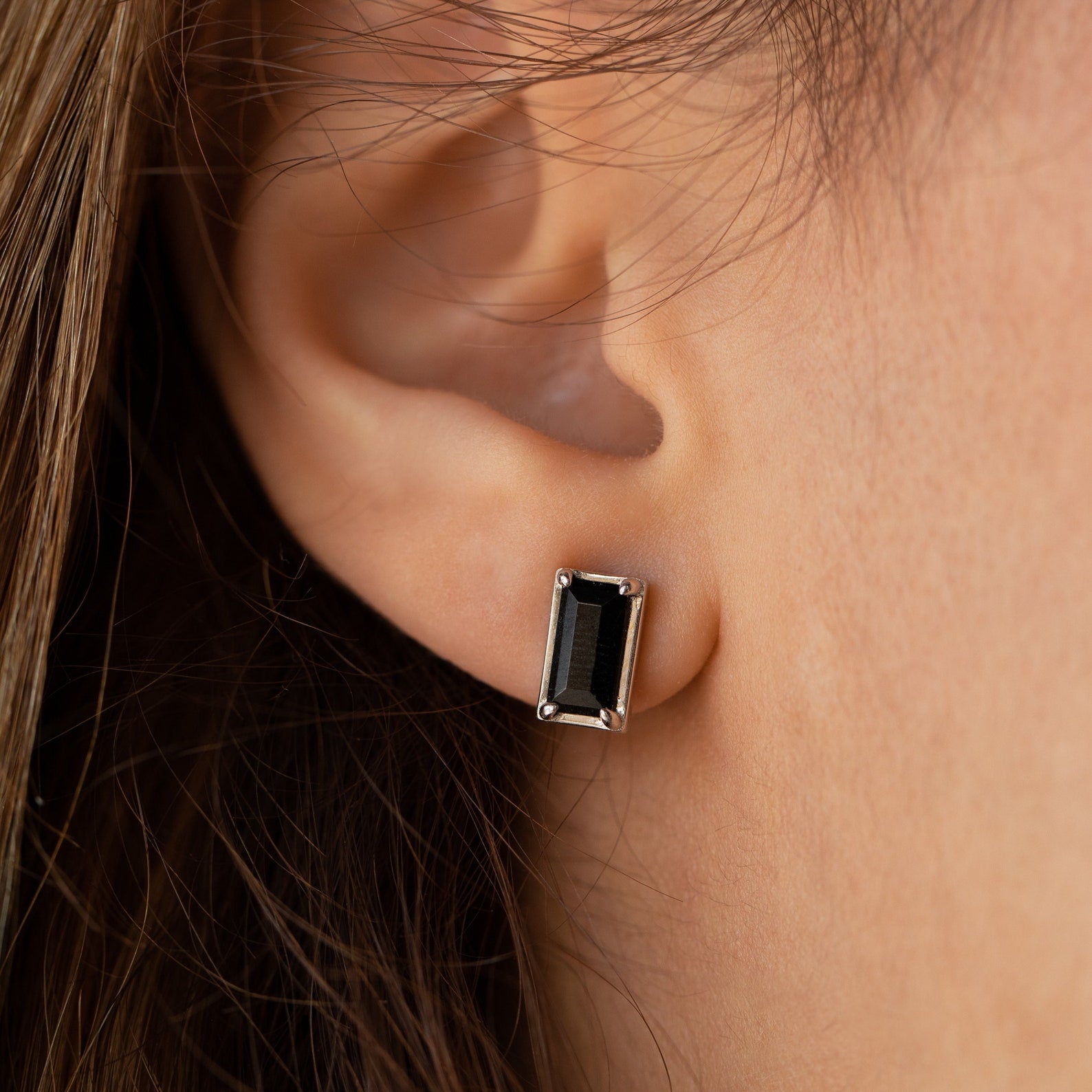 Close-up of an ear wearing Rectangle Black Onyx Studs—rectangular black stone earrings in a silver setting, ideal for anyone who appreciates classic vintage style.