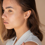 Woman with brown hair wearing Diamond Heart Huggies, looking to the left against a neutral background—an elegant gift for any occasion.