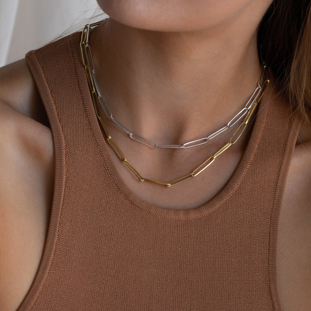 Woman wearing a brown tank top with layered statement necklaces, including the Custom Link Chain Necklace in bold gold and silver tones.