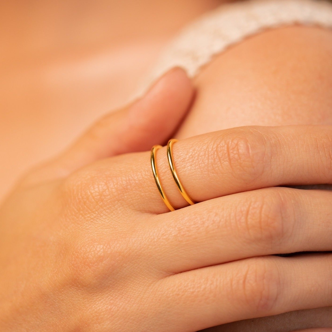A hand wears the Everly Thin Duo Band on the middle finger, a simple ring that's perfect for stacking.