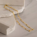 The Custom Link Chain Necklace, displayed on white marble slabs, makes a bold and stunning statement.