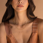 A woman wears three labeled gold chains: Satellite Chain (16”), Alice Snake Chain (17”), and Figaro Chain (18”).