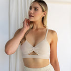Woman wearing the Kara Body Chain and a beige bralette, styled with trendy jewelry, looks to the side while standing in soft natural light.