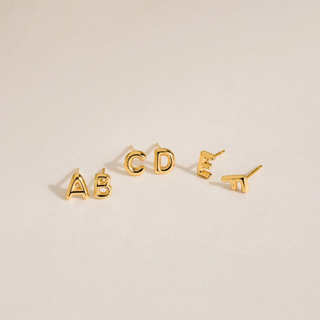 Five gold Bubble Letter Studs—A, B, C, D, and E—displayed on a neutral background. Ideal for personalized style or as a thoughtful bridesmaid gift.