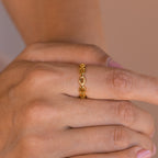 A hand wears the Reese Link Ring, a delicate minimalist chain ring, on the middle finger, with neatly manicured nails.