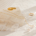 The Ariel Pearl Necklace makes perfect bridesmaid jewelry, elegantly displayed on textured surfaces.