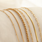 Six Essential Bracelet Chains with polished finishes are displayed on a soft, light-colored fabric background.