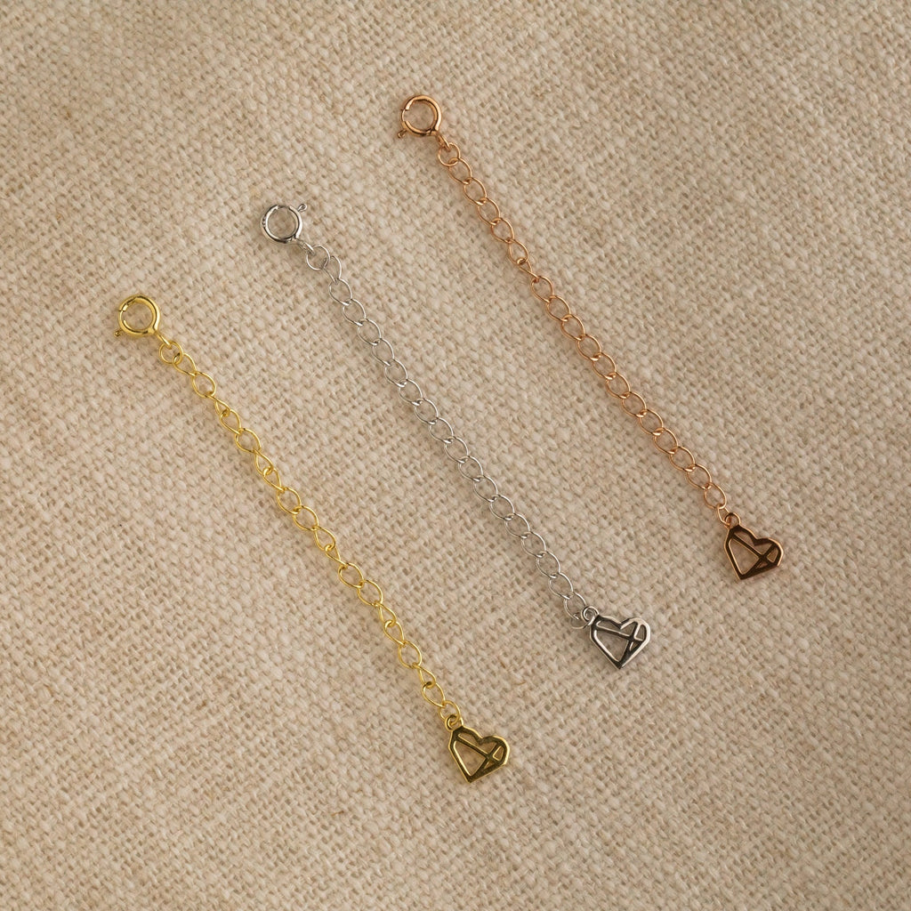 The Chain Extender in Sterling Silver is displayed on a beige fabric background—perfect to personalize jewelry or adjust necklaces and bracelets for the ideal fit.