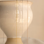 Three Dainty Chain Necklaces in gold, silver, and rose gold form a chic stack, elegantly draped over a white ceramic vase for a minimal look.
