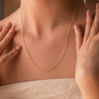 A woman models the Dainty Chain Necklace, her hands near her collarbone and dressed in a beige top for a minimalist look.