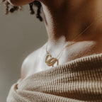 Close-up of a woman's neck wearing the Engraved Interlocking Necklace, featuring gold interlocking circles and a pendant engraved with "Sofia"—an ideal personalized anniversary gift.