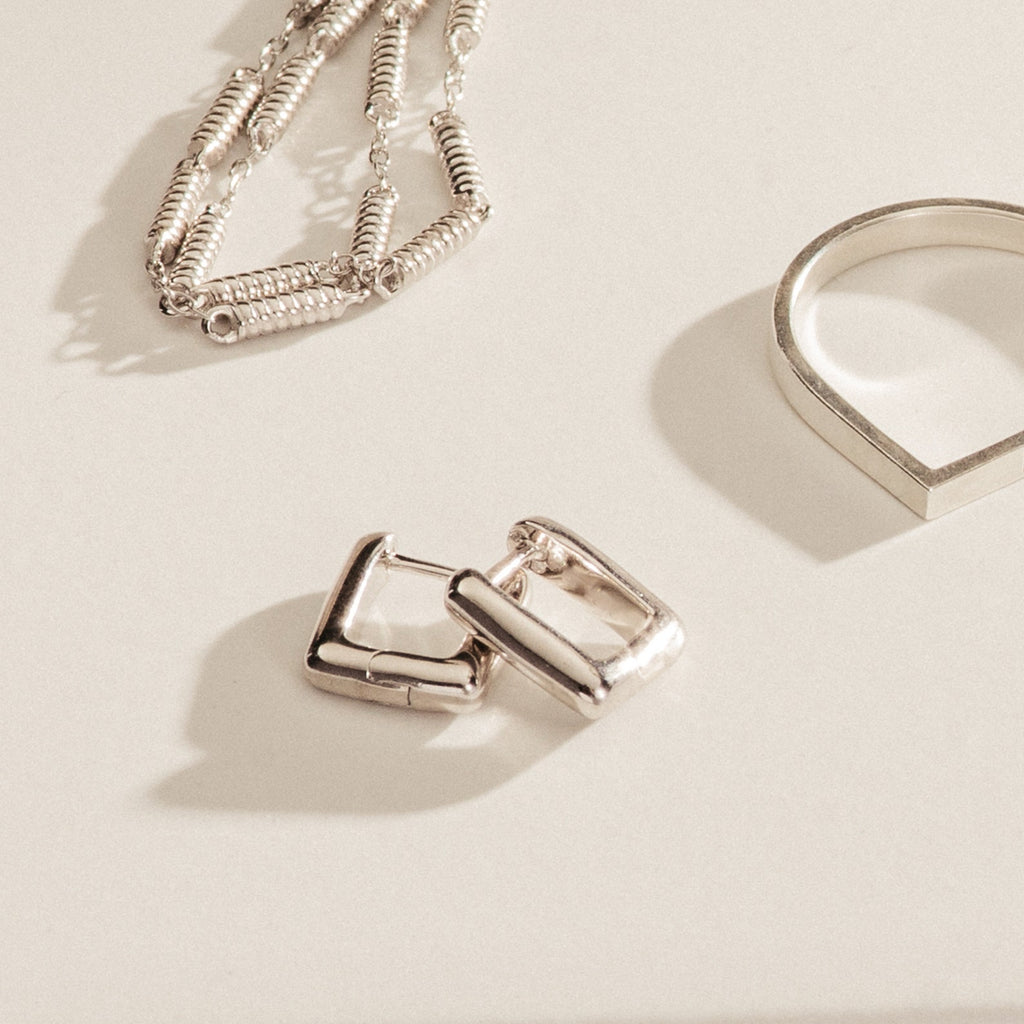 The Kelsey Link Earrings are displayed on a light surface—a minimal silver jewelry accessory for effortless, contemporary style.