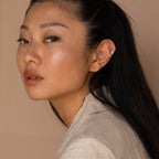 A woman with long hair and a white shirt wears Starry Night Ear Cuffs—stylish, no-piercing earrings.