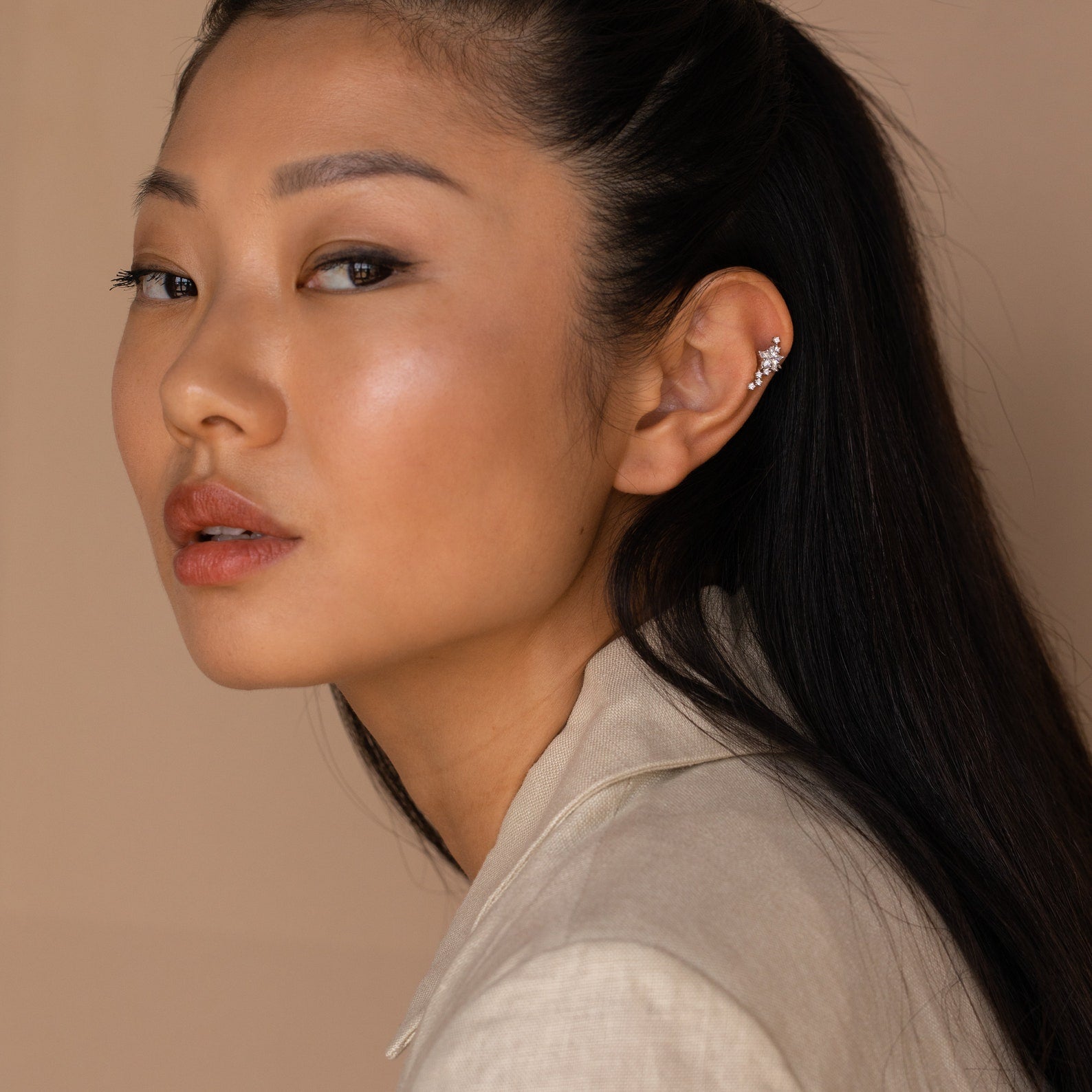 A woman with long hair and a white shirt wears Starry Night Ear Cuffs—stylish, no-piercing earrings.