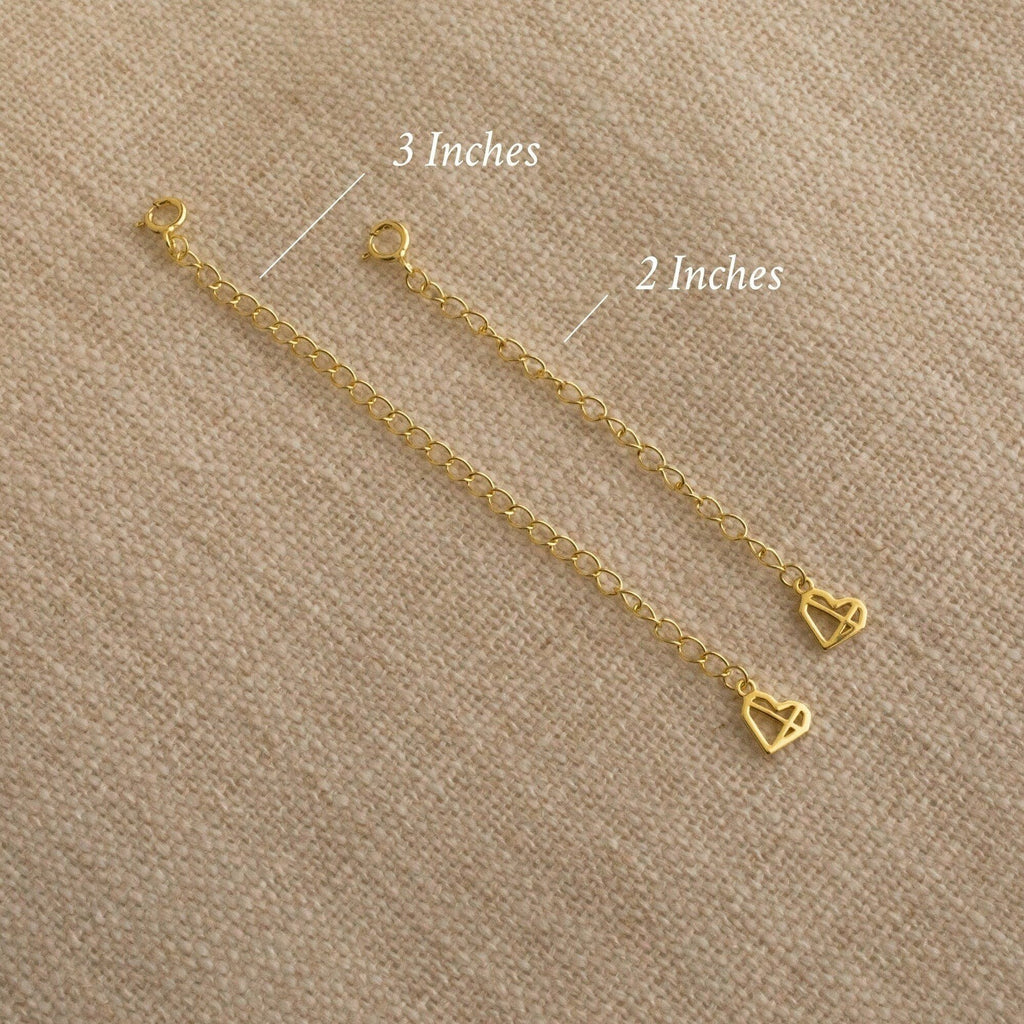 Two Chain Extender gold adjustable chains with heart charms, sized 3" and 2", are displayed on beige fabric—ideal for lengthening your favorite necklaces or bracelets.