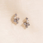 A pair of Seine Diamond Studs featuring cultured pearls and sparkling gemstones, displayed on a soft cream fabric background—perfect as elegant wedding earrings.