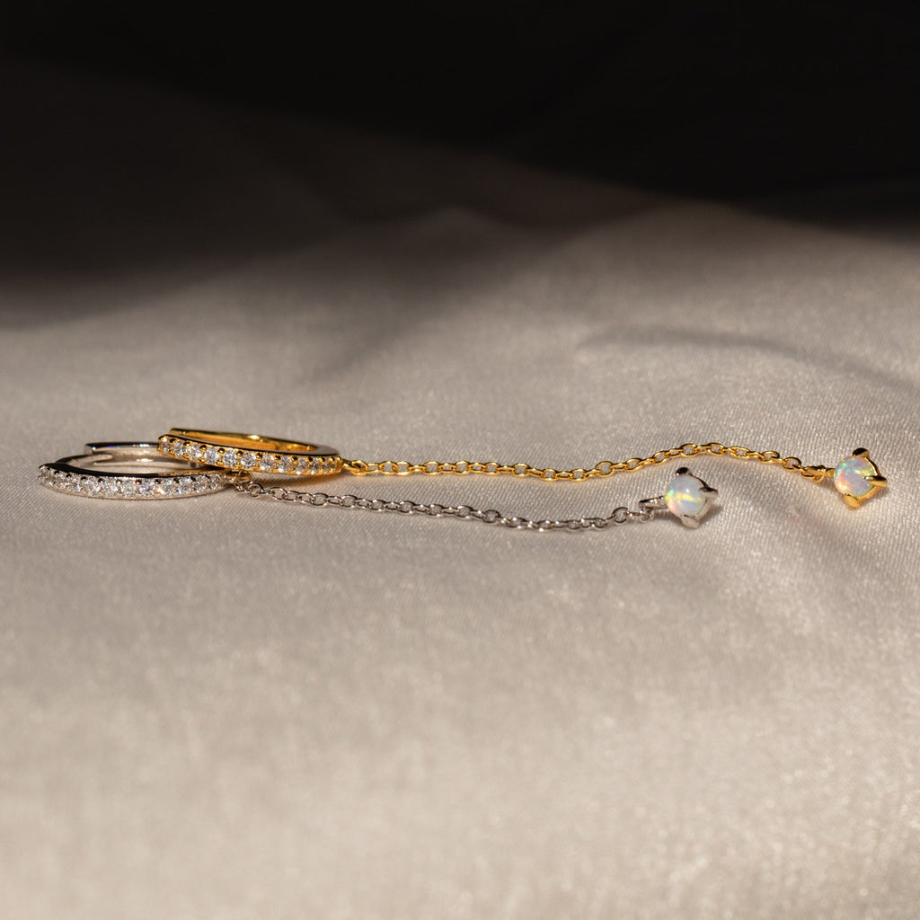 The Opal Stud & Pave Hoop Earrings set features two delicate chain earrings, one gold and one silver with crystal accents—perfect for mixing and matching for versatile style.