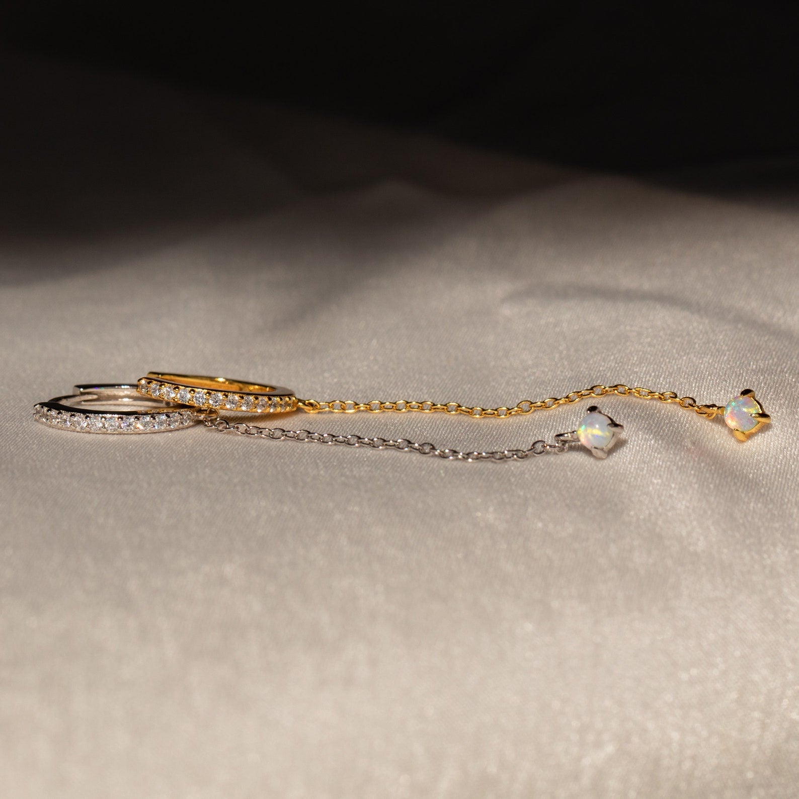 The Opal Stud & Pave Hoop Earrings set features two delicate chain earrings, one gold and one silver with crystal accents—perfect for mixing and matching for versatile style.