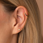 Close-up of an ear wearing the Opal Stud & Pave Hoop Earrings, featuring a gold chain connecting an upper cuff to a lower opal stud for versatile, elegant style.