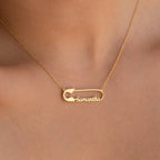The Safety Pin Name Necklace, featuring "Samantha" and worn around the neck, is a unique personalized accessory that stands out as a statement piece.