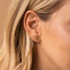 Close-up of a woman's ear adorned with Constellation Earrings, inspired by astrology, and featuring straight blonde hair.