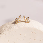 Seine Diamond Studs featuring clusters of clear gemstones and a cultured pearl, beautifully arranged on a textured white surface—ideal as elegant wedding earrings.