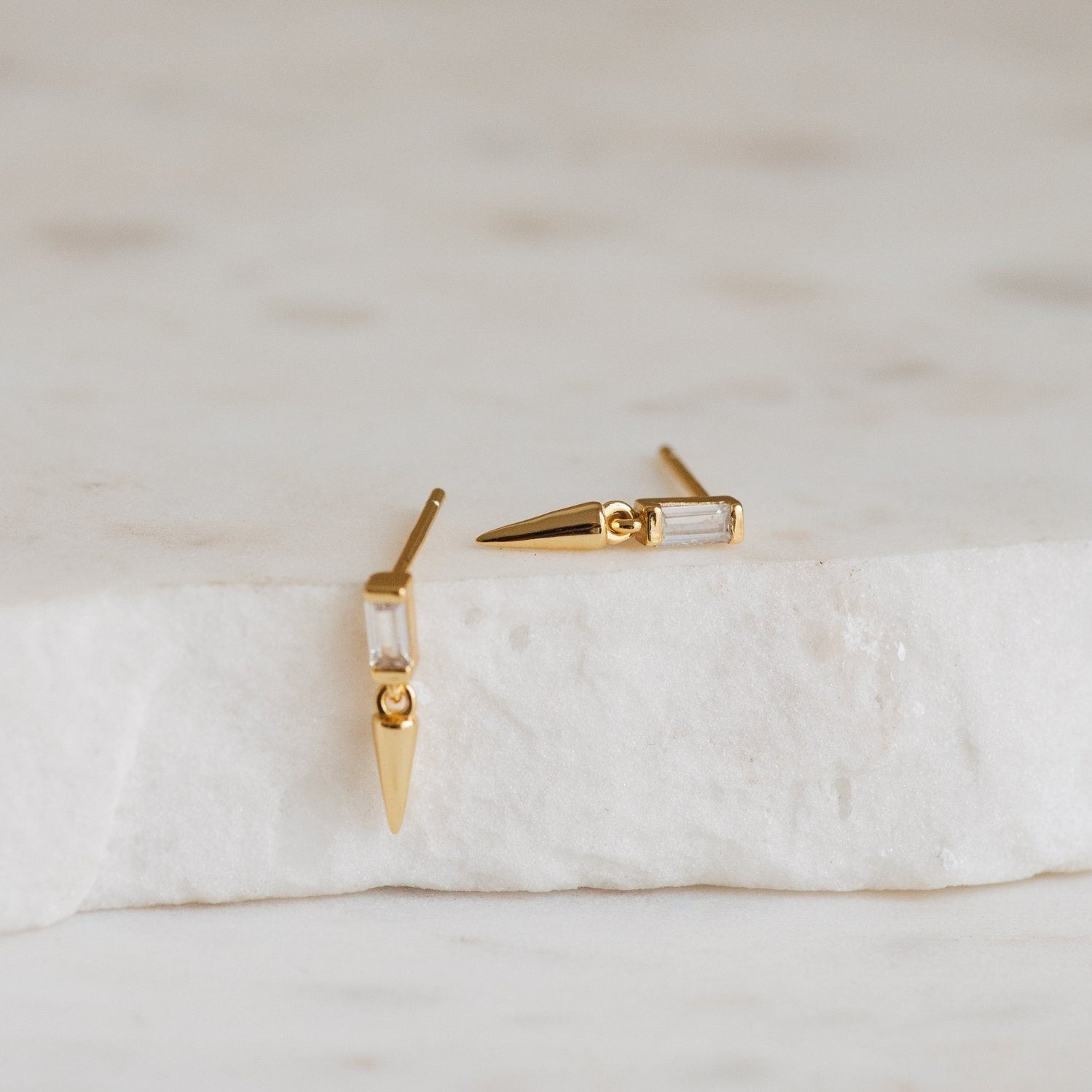 The Wren Spike Studs are lightweight gold earrings with a spike shape and CZ baguette diamonds.