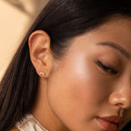 Woman with long dark hair wearing Odessa Marquise Studs—delicate floral earrings, perfect as an elegant bridal gift.