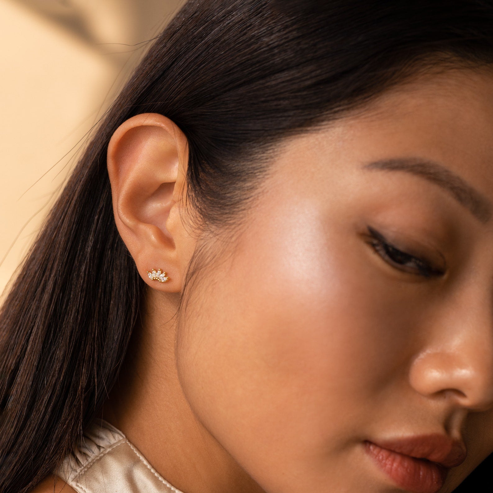 Woman with long dark hair wearing Odessa Marquise Studs—delicate floral earrings, perfect as an elegant bridal gift.