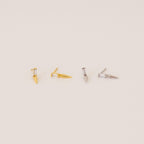 Two pairs of Wren Spike Studs, one gold and one silver, each with a spike-shaped design and lightweight feel, displayed on a light background.