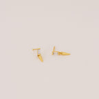 The Wren Spike Studs are lightweight, small spike-shaped earrings featuring CZ baguette diamonds and a pointed spike detail, set against a plain background.