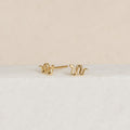 Dainty jewelry lovers will adore the Tiny Python Studs—petite gold earrings with elegant curves, perfect for a boho-luxe style and shown on a white textured background.