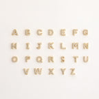 A set of letters on a white background, inspired by the Pave Initial Huggies—ideal for gifting someone a personalized touch.