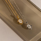 Initial Pendant Necklace in Gold with the letter A and White Gold with the letter K in a vintage serif font lay side by side.