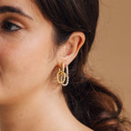 Close-up of a woman wearing three gold and silver hoop earrings, featuring the Kenzie Chain Link Earrings, with her hair tied back for an edgy jewelry look.