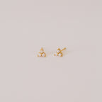 The Maud Pearl Studs are elegant gold earrings featuring three petite pearls in a triangle design—a timeless, luxurious gift for any occasion, shown simply on a light background.
