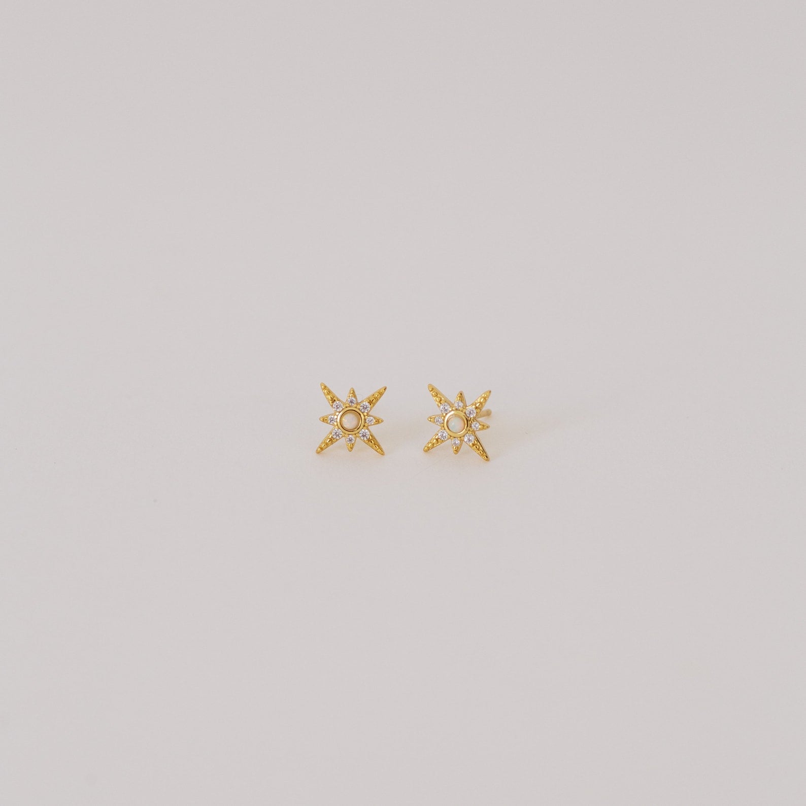 Starburst Studs featuring a central pearl, inspired by opal earring designs, shown on a plain light background.