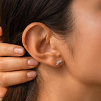 Close-up of a woman's ear wearing the elegant Odessa Marquise Studs and a small silver crystal ear cuff; her hand rests near her ear.
