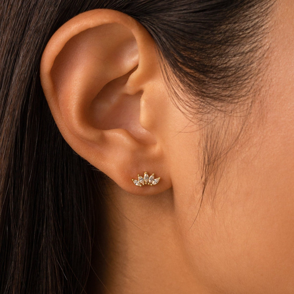Close-up of a woman's ear wearing Odessa Marquise Studs—small gold cluster earrings with clear gemstones, ideal as floral earrings or a delicate bridal gift.