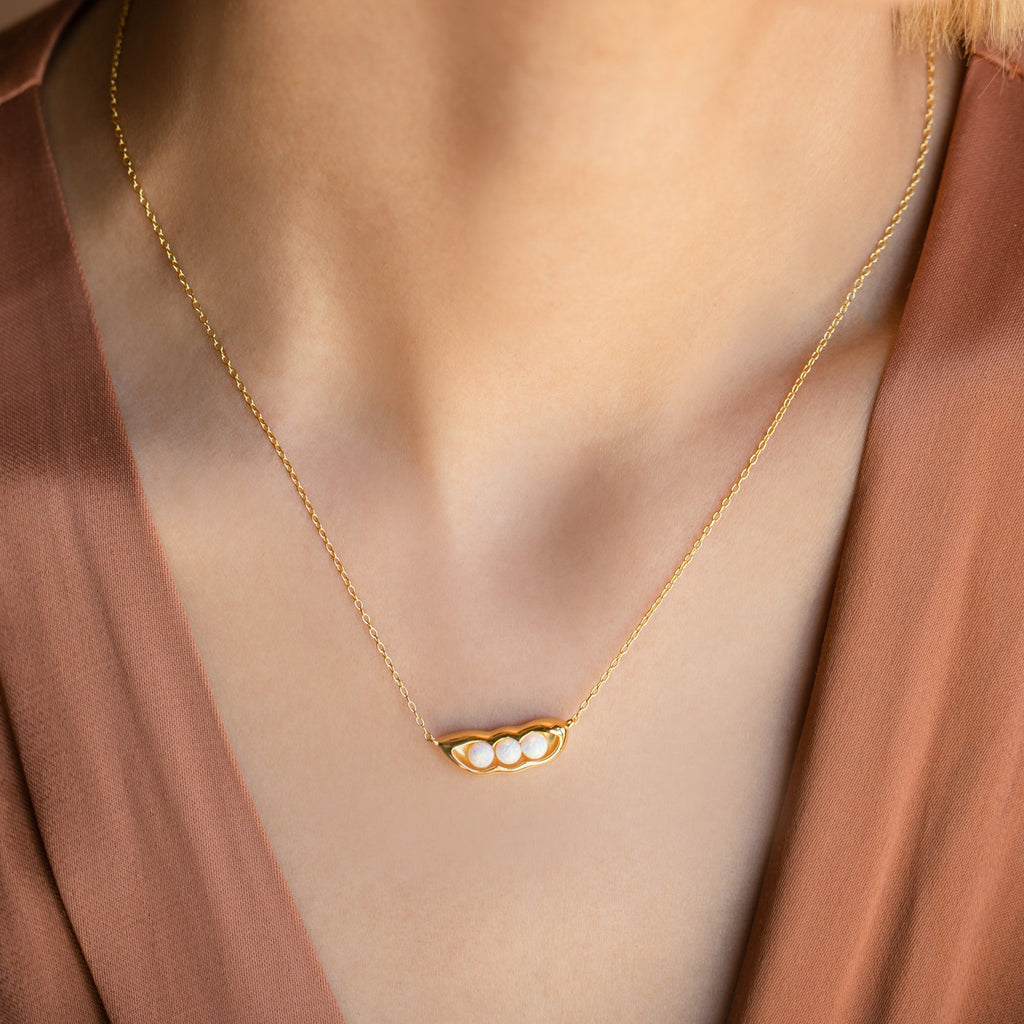 Peas in a Pod Necklace featuring three pearls adds a touch of meaning when paired with a v-neck brown top.