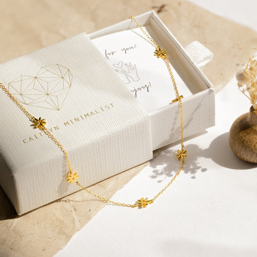 The Flower Child Necklace draped on a textured jewelry box, accompanied by a thank you card and dried flowers—an elegant addition to any bohemian jewelry collection.