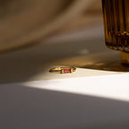 The Empire Garnet Ring, featuring a gold band, rests elegantly on the table.