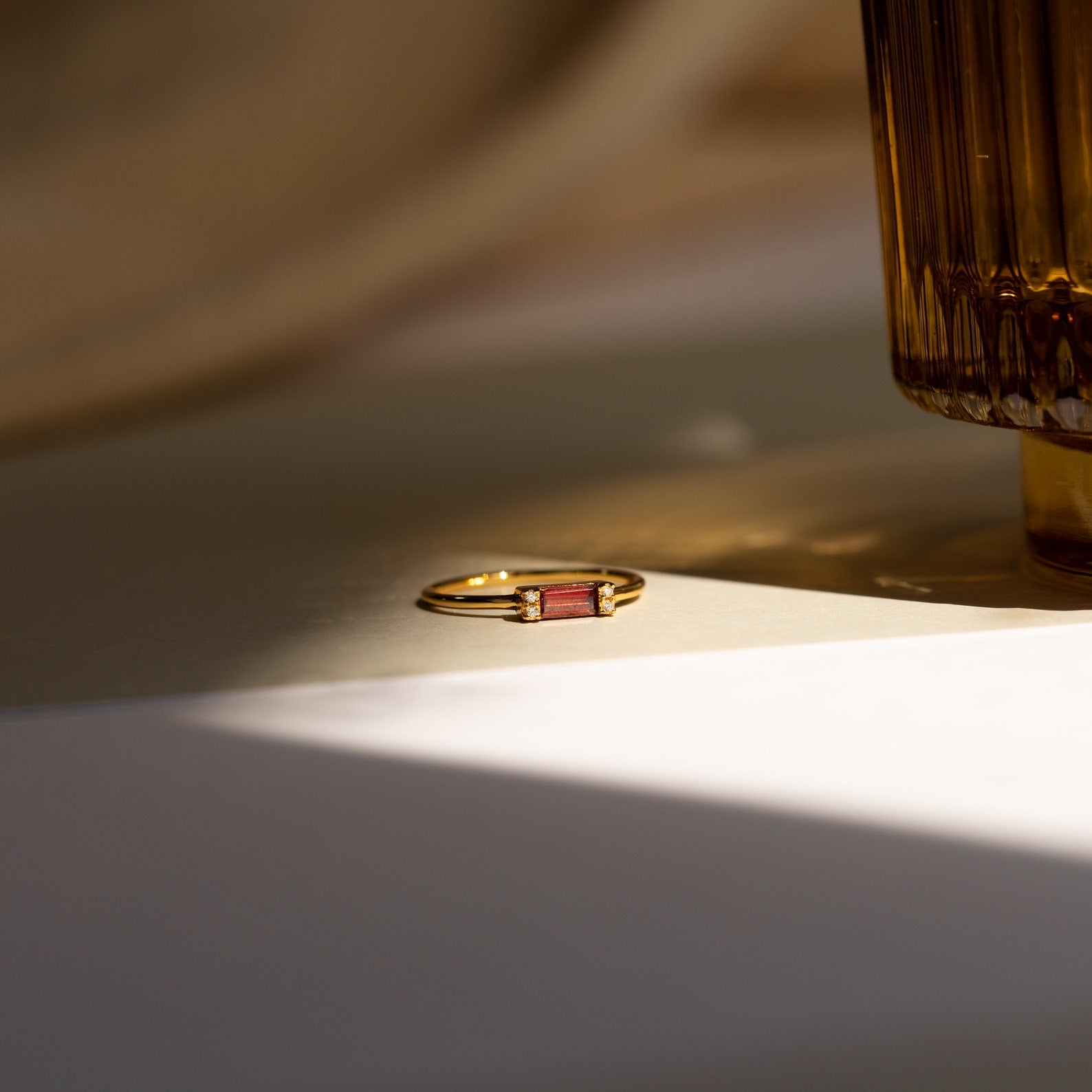 The Empire Garnet Ring, featuring a gold band, rests elegantly on the table.