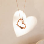 Rose gold heart pendant casting a shadow on a light background, perfect for the Custom Bead Heart Necklace.