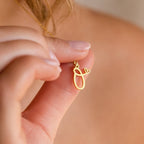 A hand holds the Letter Heart Necklace, a gold pendant featuring a cursive initial and small heart—an elegant, minimalist everyday accessory perfect for adding personal style.