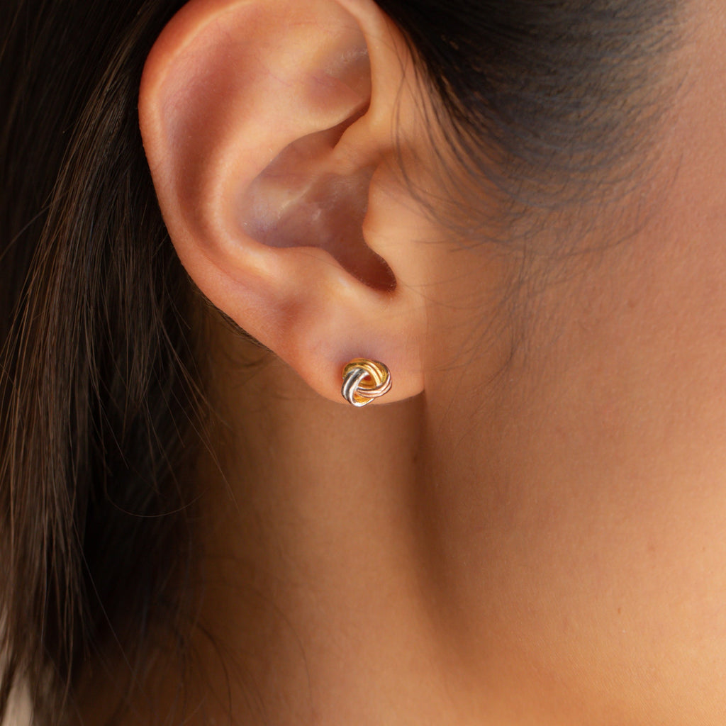 Close-up of an ear wearing a Trinity Knot Stud—an elegant gold earring perfect for everyday wear or as a thoughtful anniversary gift.