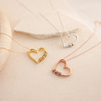The Custom Bead Heart Necklace is shown in gold, silver, and rose gold. Each heart-shaped pendant features personalized engraved beads and is displayed on a beige surface.