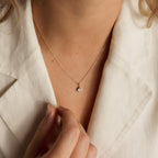 Someone wearing a cream blazer and the Custom Birthstone Necklace, featuring a small, round gold pendant—an elegant and meaningful jewelry piece.
